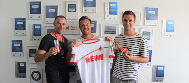 Friedhelm Mienert, Felix Benckendorff und Lukas Schuhmacher halten Produkte vom FC Köln