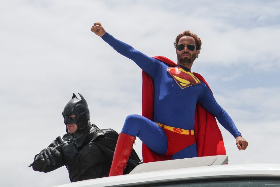 Zwei Männer, verkleidet als Superman und Batman, posieren vor der Kamera.