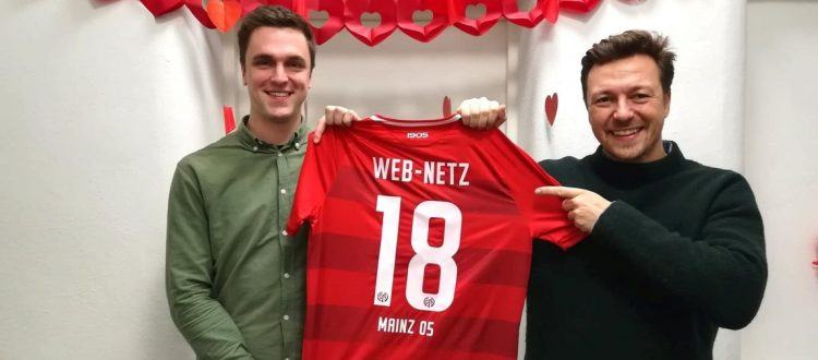 Lukas Schumacher und Felix Benckendorff halten ein Trikot von Mainz 05 in die Kamera