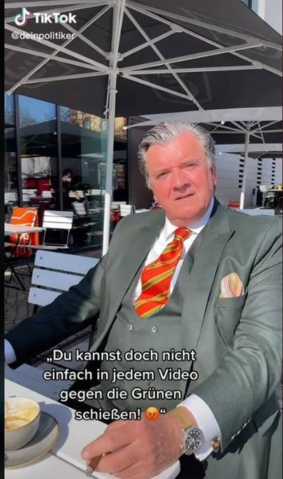 Screenshot eines TikTok Postings von Uwe Dorendorf: Er sitzt im Anzug in einem Kaffee.