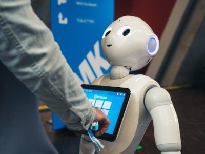 Ein kleiner Roboter interagiert mit einem Menschen